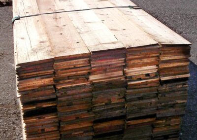 Ein Stapel 8 mm starker Altholz-Lamellen, von vorne fotografiert, zeigt die präzisen Querschnitte und die gleichmäßige Dicke der Lamellen.