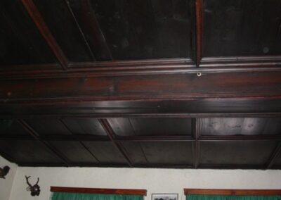 Komplette Ansicht einer geborgenen, antiken Kassettendecke mit kunstvollen Holzverzierungen und quadratischen Feldern.