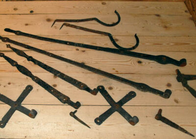 Eine Auswahl an historischen, eisernen Türbeschlägen und Bändern, die für die Restaurierung antiker Türen verwendet werden können.