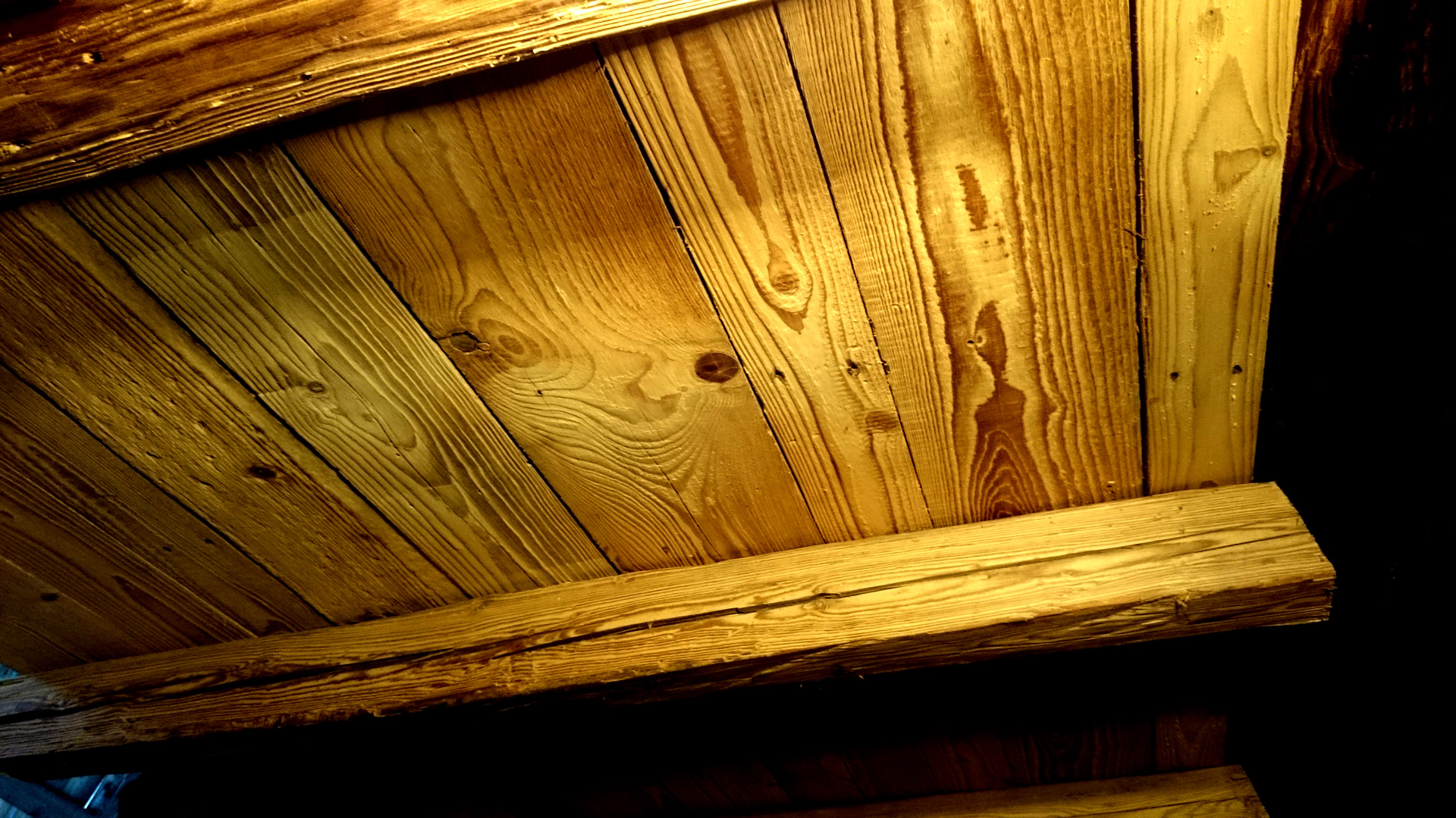 Nahaufnahme von originalen Altholz-Dachschalungsbrettern, professionell gebürstet und mit erhaltener Originalkante für maximale Authentizität.