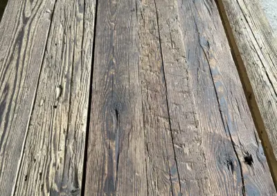 Nahaufnahme eines Stapels handgehackter Altholzbretter in rustikaler, dunkler Sortierung