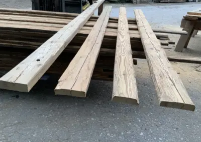 Auswahl von vier handgehackten Altholz-Sparren in 3-seitig sichtbarer Ausführung, die die individuelle Textur und Patina jedes Balkens zeigen.