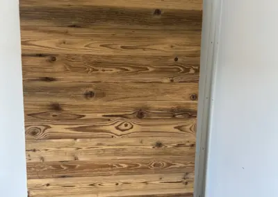 Frontale Ansicht der sortierten Altholzbretter vor der Montage als Wandverkleidung zur Prüfung des Farbbildes.