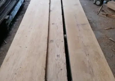 Blick von oben auf einen Stapel fertig aufbereiteter und geschnittener Dübelbäume, die ihre markante Breite und Längen von bis zu 6 Metern zeigen.