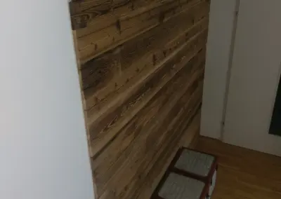 Seitliche Ansicht einer montierten Wandverkleidung aus sonnenverbranntem Altholz im modernen Wohnbereich.